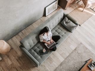 Frau mit Laptop auf Sofa
