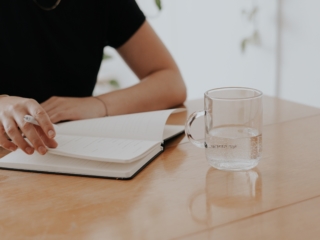 Frau schreibt am Tisch