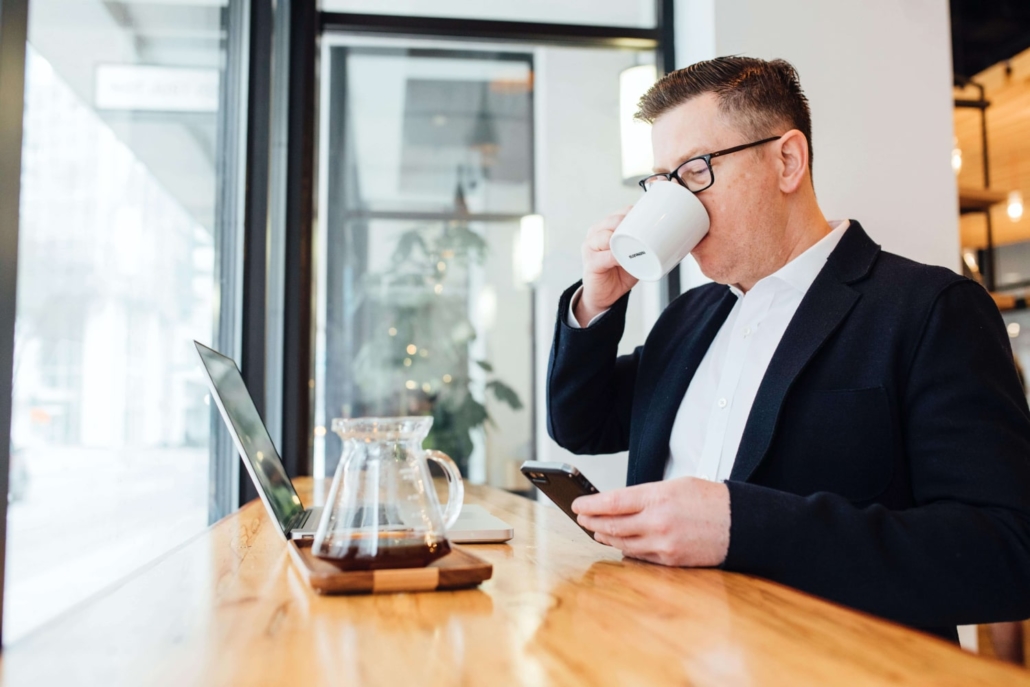 Mann mit Kaffeetasse und Computer